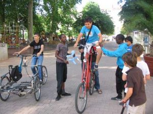 Plusieurs jeunes personnes autour d'un tall-bike et autres vélos bizarres